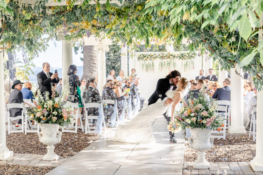 Bride and groom kiss down the isle after wedding ceremony at jefferson street mansion captured by sacramento wedding photographer