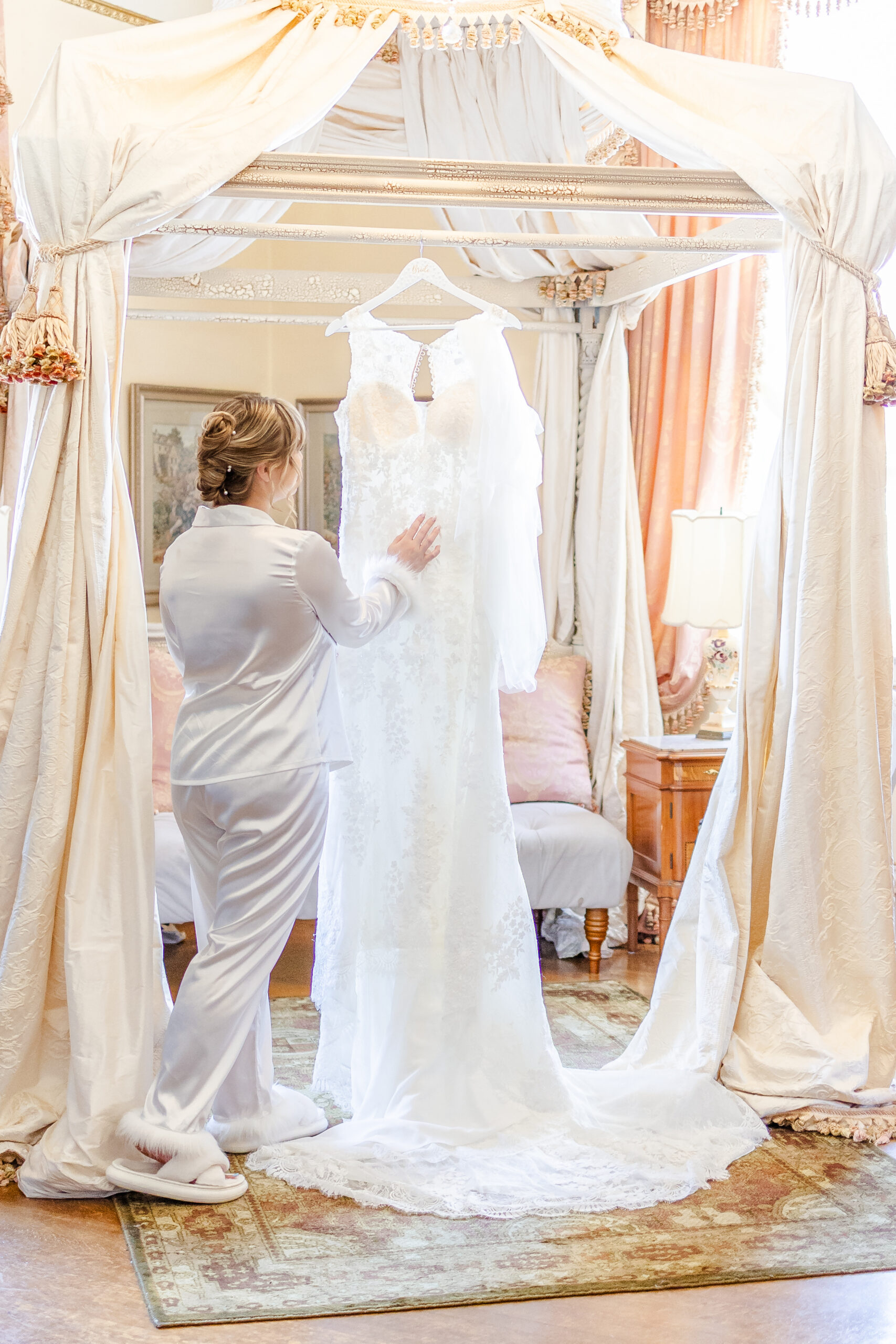bride admires her wedding dress in the bridal suite at jefferson street mansion captured by sacramento wedding photographer