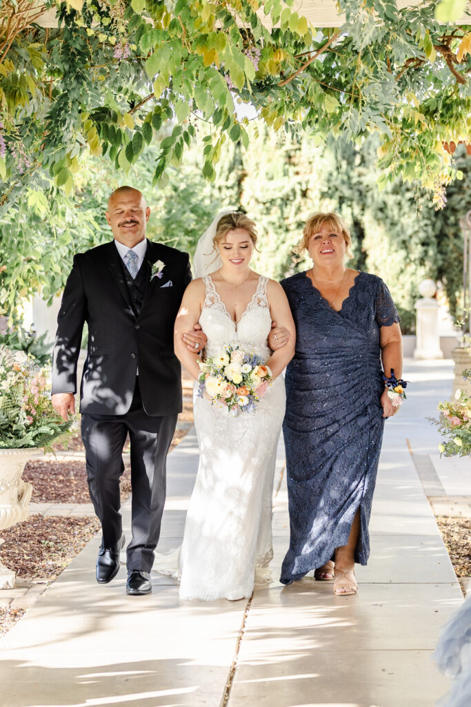 bride and parents walk down the isle to her groom at jefferson street mansion captured by sacramento wedding photographer