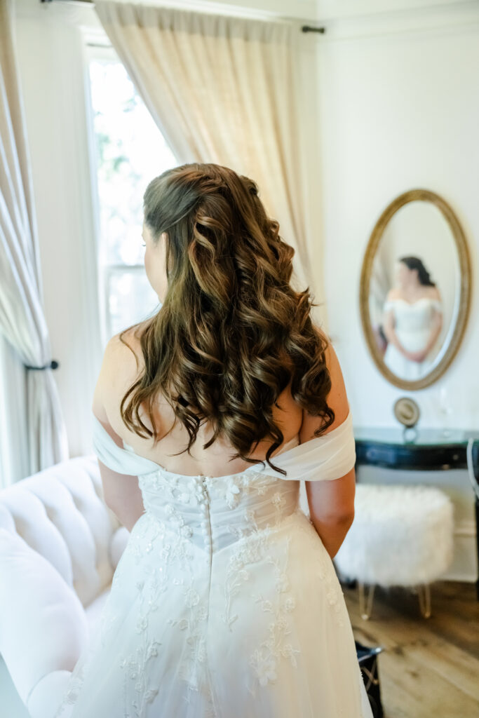 Bride admires her look at Park Winters in Winters, California captured by a sacramento wedding photographer