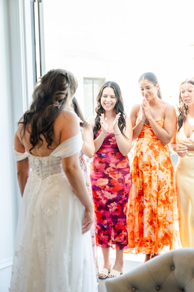 bride shows bridesmaids her dress for the first time at Park Winters in Winters, California captured by a sacramento wedding photographer