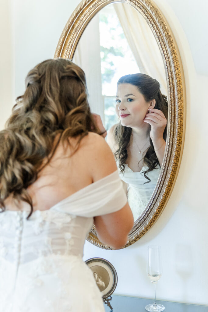 bride puts on earrings at Park Winters in Winters, California captured by a sacramento wedding photographer