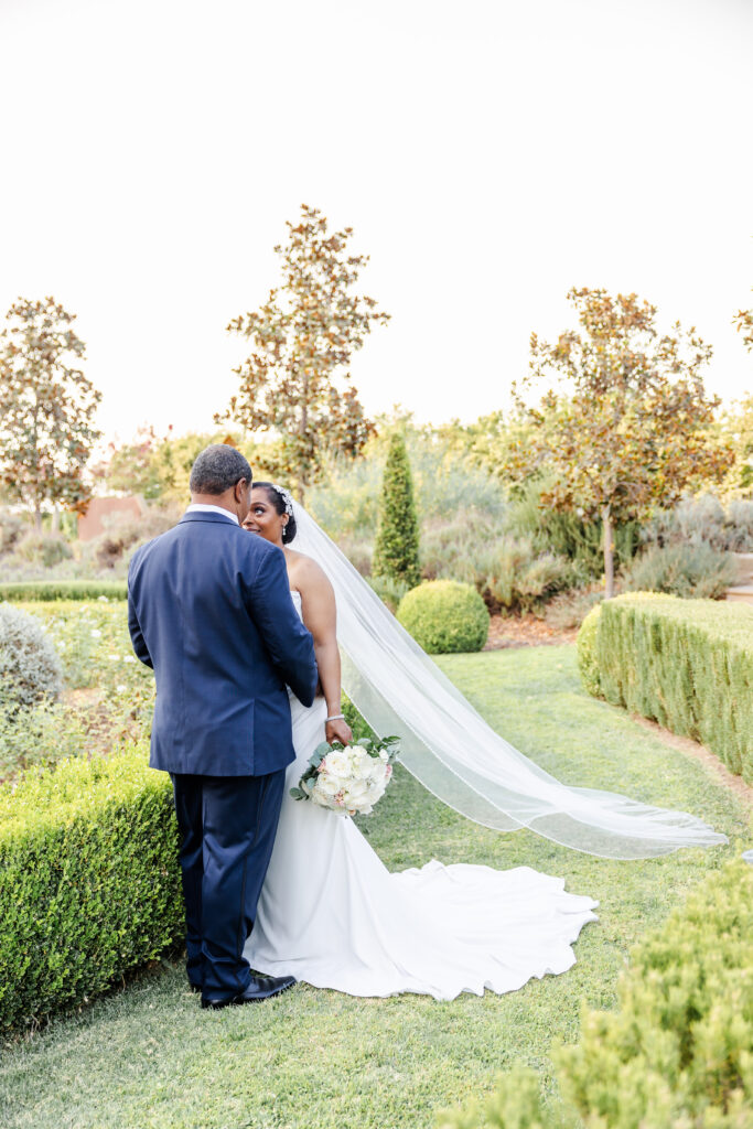 Bride and Groom stand in the garden paths at Park Winters Wedding captured by Sacramento Wedding Photographer
